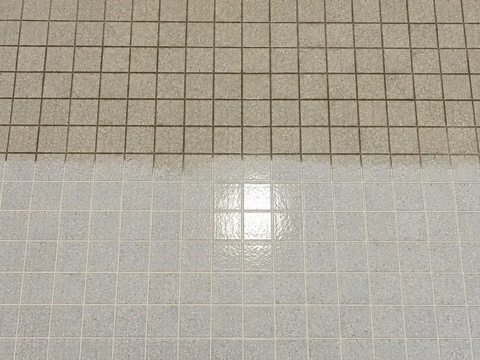 Tile floor showing dingy grout next to freshly cleaned tile and grout