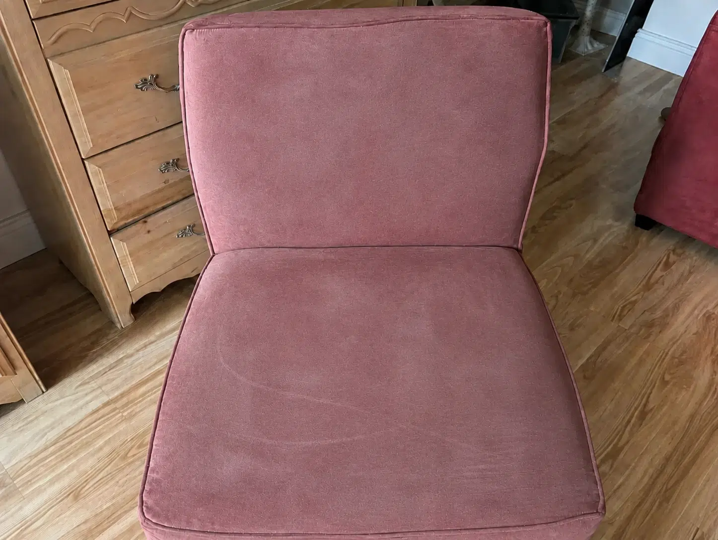 Same fabric accent chair before cleaning, faded and dull